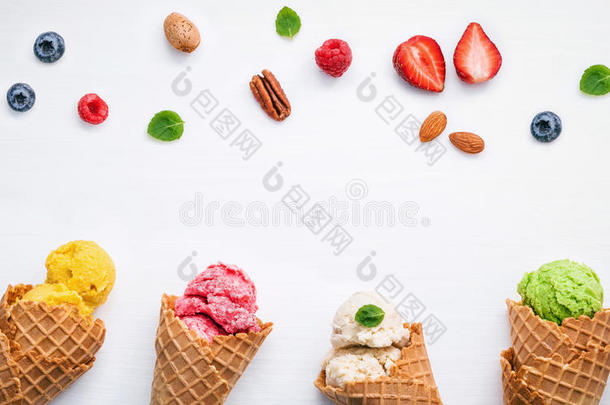 彩色冰淇淋与锥和各种水果树莓，蓝莓，草莓和薄荷叶设置在白色