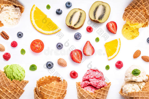 <strong>彩色冰淇淋</strong>与锥和各种水果树莓，蓝莓，草莓和薄荷叶设置在白色