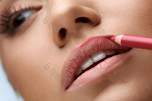 面部化妆。 美丽的女人用唇笔，铅笔做嘴唇