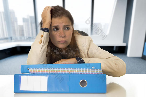 绝望的女商人在办公桌上承受压力和头痛，看上去很担心
