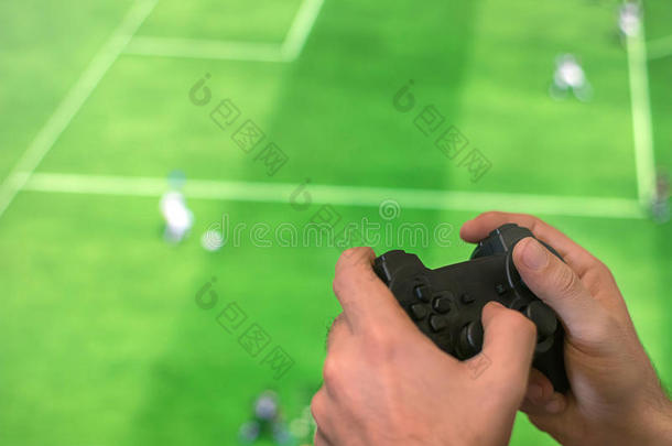 手握游戏控制器玩足球游戏。