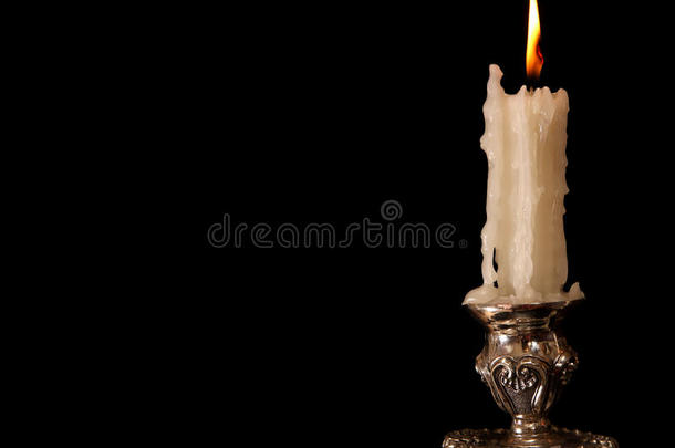 燃烧的旧蜡烛<strong>复古</strong>银青铜<strong>烛台</strong>。黑色背景。