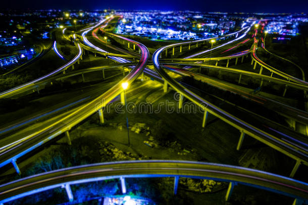 空中公路立交环和掉头，因为城市的灯光在夜间增长，光速在一条新的道路上充满活力