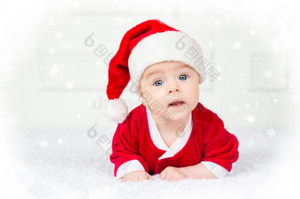 有趣的圣诞宝宝穿着圣诞老人的服装躺在白色的背景上