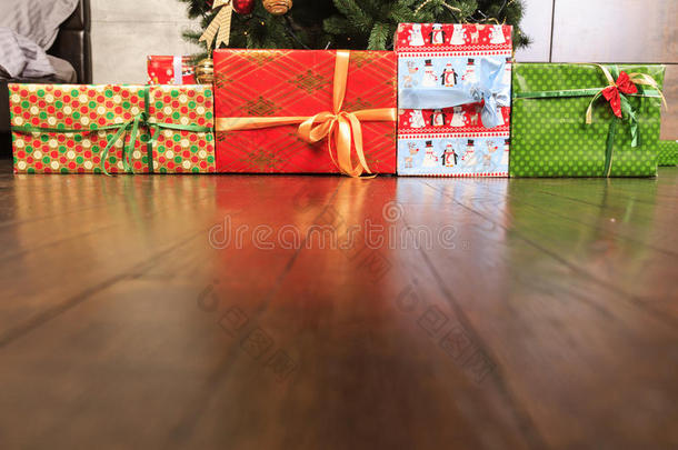 圣诞节和新年礼物在木地板上的树下