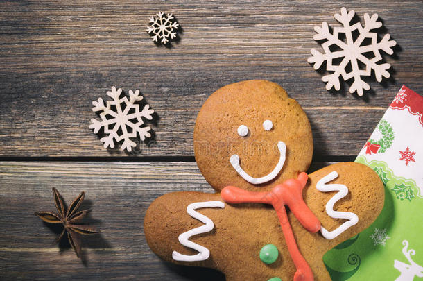 木头上的姜饼人。 圣诞假期背景与姜饼饼干，装饰雪花，餐巾纸和香料