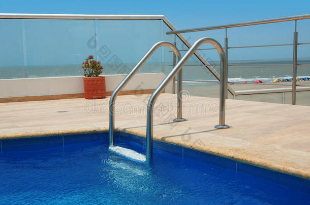 游泳池的角落有大理石<strong>边框</strong>、<strong>蓝色</strong>陶瓷墙和游泳池梯