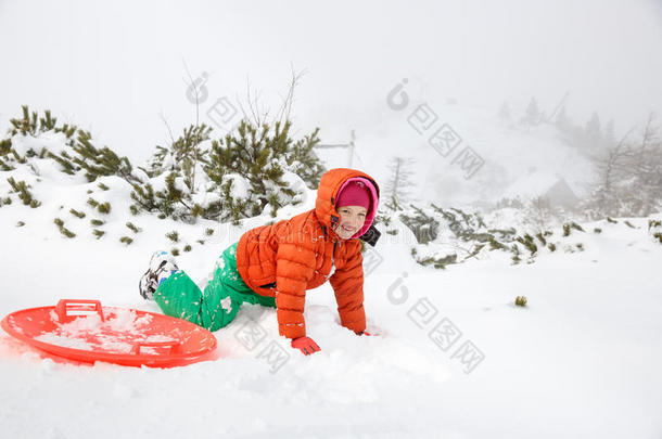 美丽的女孩玩塑料<strong>碟子</strong>雪橇，掉进雪里