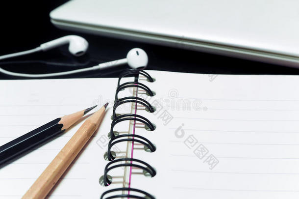 黑色铅笔和木制铅笔，书和笔记本电脑箍在茶杯上