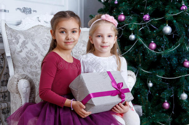 女孩们在圣诞树下拿着大礼盒