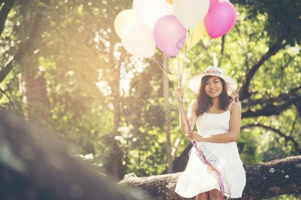 美丽的女人在公园里有五颜六色的气球。