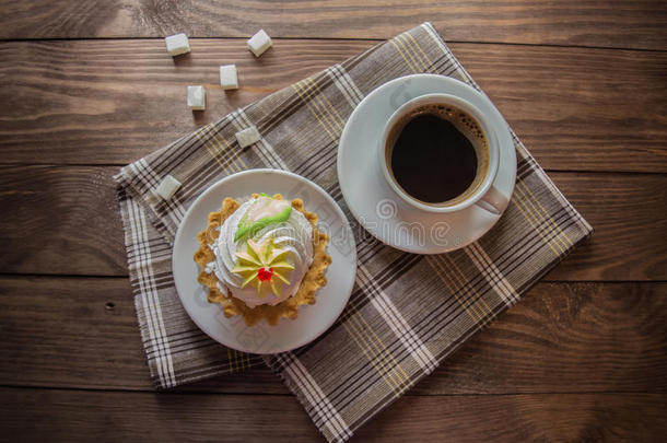 一杯热咖啡和蛋糕，木制背景上的精制糖。 上面的风景。 特写镜头