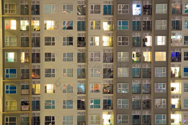 夜晚发光的公寓窗户，在那里，每个居住者都有自己的隐私，在计划好的高层。 电力