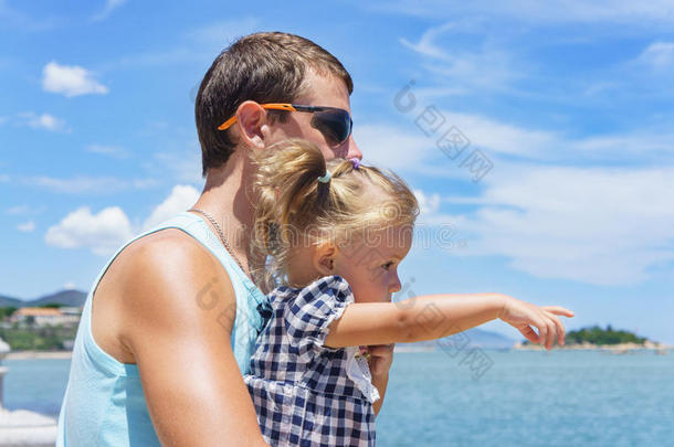 爸爸和女儿在<strong>海边</strong>的长廊上<strong>玩耍</strong>。 年轻人，小女孩
