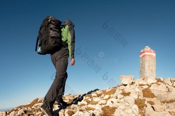 带背包的成人游客在山顶散步。 最后一步到山顶石