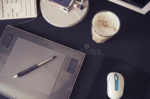 在黑色桌子上有图形平板电脑和钢笔、键盘和鼠标的设计师的空工作空间。 简约的现代风格