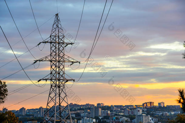 电力塔和电力线轮廓在多云的日落。