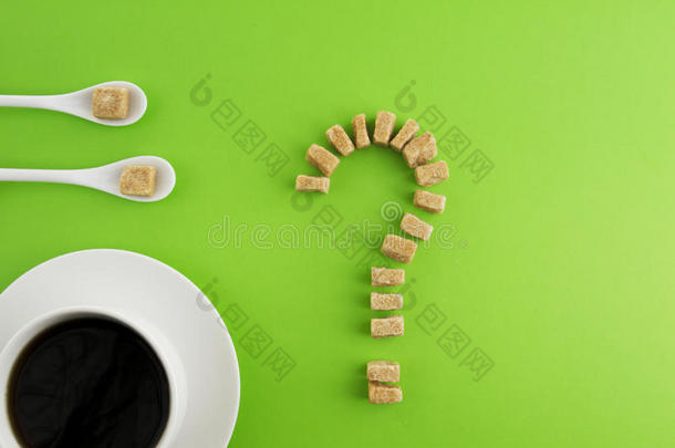 饮食，不健康的糖瘾概念。 白色咖啡或茶，两个勺子和红糖立方体作为问号