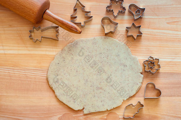 圣诞甜面团在木板上，用擀面杖和饼干切割机