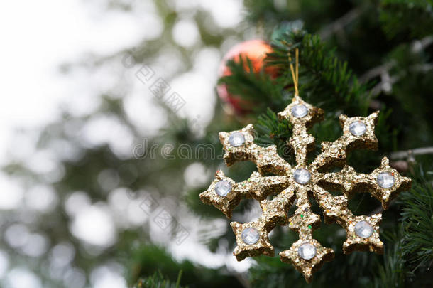 <strong>金色闪亮</strong>的圣诞装饰品挂在一棵绿色的松树上