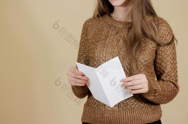 女孩阅读空白白色传单小册子。 分发传单