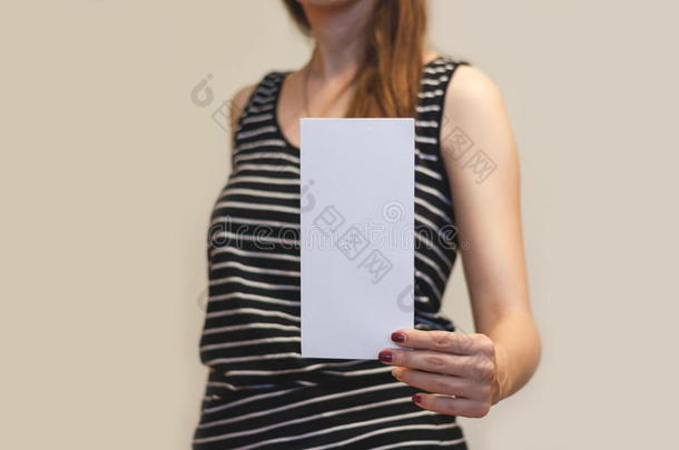 女孩展示空白的白色传单小册子。 分发传单