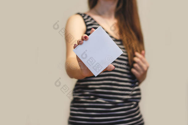 女孩展示空白的白色方形传单小册子。 传单