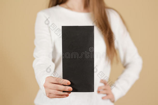 女孩展示空白的黑色传单小册子。 分发传单