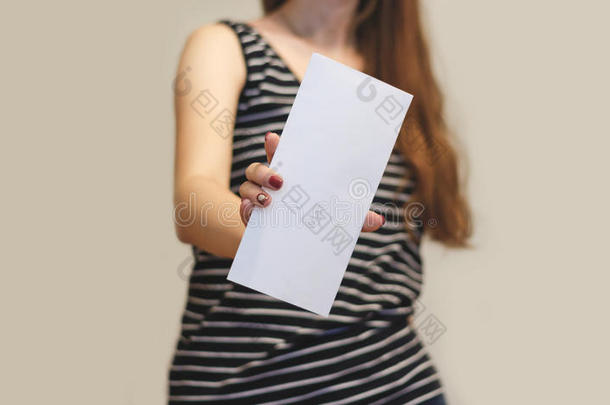 女孩展示阿斯兰空白白色传单小册子。 传单