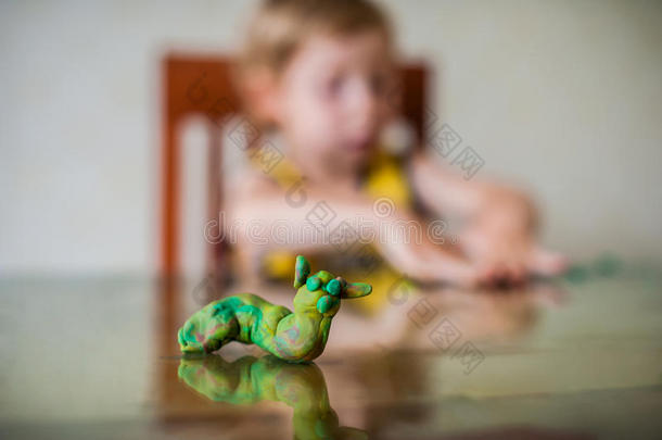 孩子们`创造力。 儿童雕塑从粘土。可爱的小男孩模具从塑料在桌子上