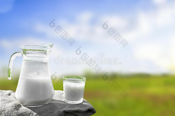 玻璃罐与牛奶和玻璃在<strong>草地</strong>上的背景下，<strong>风景</strong>如画的绿色<strong>草地</strong>与鲜花