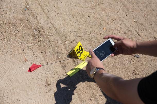法医在犯罪现场培训中使用手机用证据标记拍摄证据