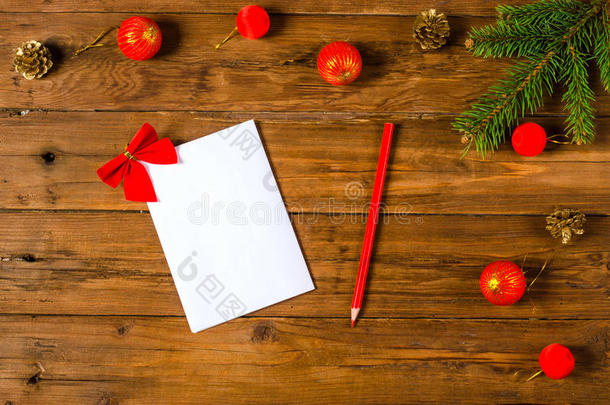 圣诞装饰品和木制背景<strong>上</strong>的<strong>一张</strong>白纸。