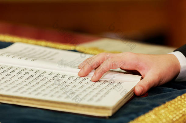男孩在2015年8月1日的成人礼上阅读犹太律法的手