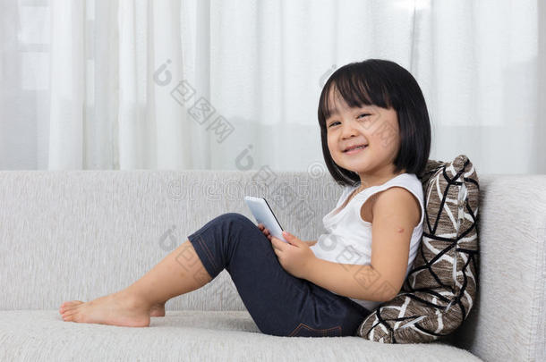 亚洲中国<strong>小女孩躺在沙发上</strong>拿着电话