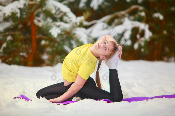 美丽的女人在雪地里户外做瑜伽