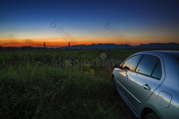 夕阳西下的农田乡村公路上的汽车