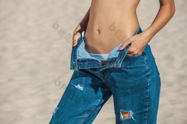 一个年轻的女孩穿着牛仔裤，在减肥和节食后变得很大。 减少超重。