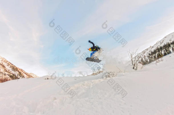 更自由的人正在从斜坡上跳入雪雾中