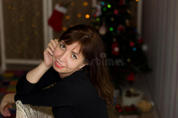 女孩坐在圣诞树的背景上。 <strong>平安</strong>夜。