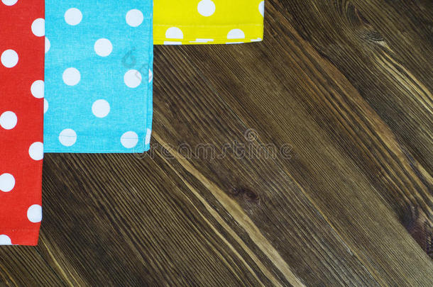 彩色圆点餐巾纸在木制背景上。