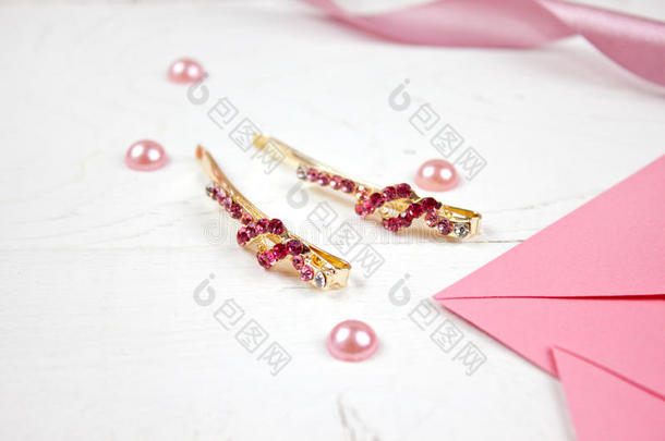 金色发夹，粉红色宝石和粉红色丝带在粉红色的背景