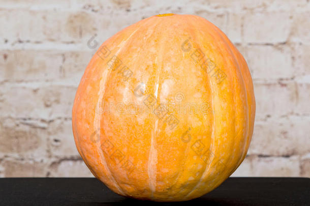 秋天南瓜感恩节背景-木制桌子上的橙色南瓜。 秋季产品。 万圣节雕刻南瓜。