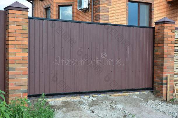 砖和金属栅栏与金属大门的现代风格设计装饰开裂砖墙表面外观。 钢栅栏门
