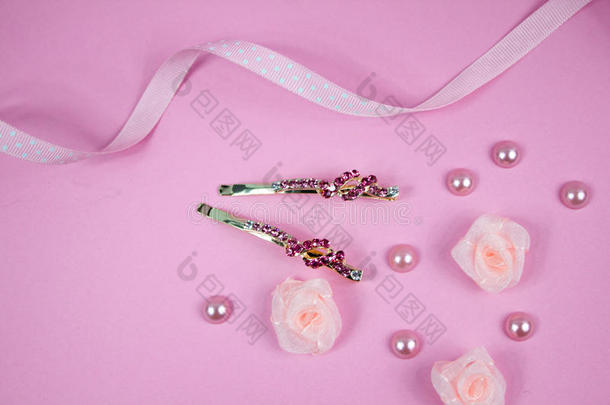 金色发夹，粉红色宝石和粉红色圆点丝带在粉红色的背景