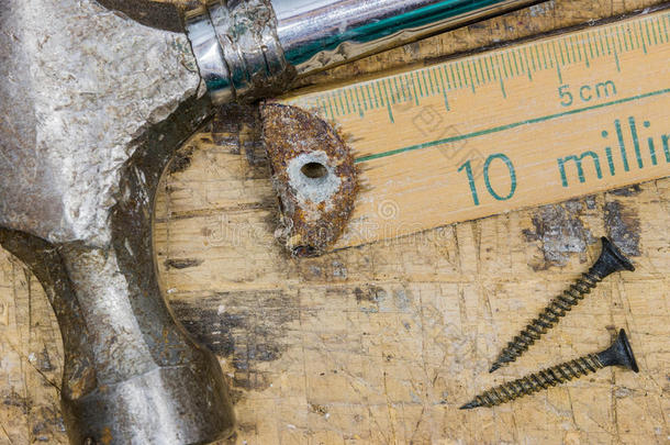 生锈的锤子、钉子和电表的特写粘在划痕上