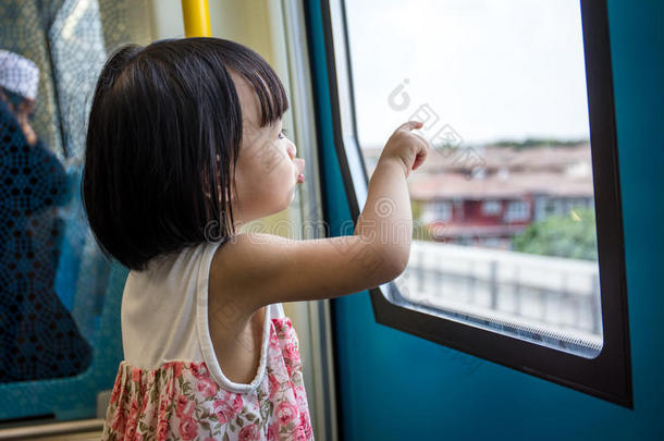 亚洲<strong>中国</strong>小女孩在火车里看着窗户旁<strong>边</strong>