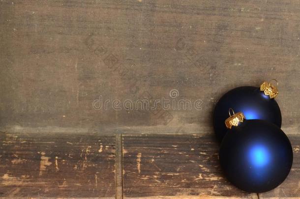 蓝色和金色圣诞装饰品边框在木制背景上