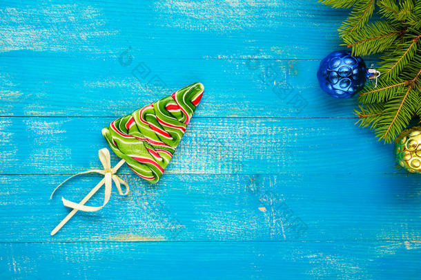 <strong>圣诞大餐</strong>：蓝色木板上云杉形式的彩色棒棒糖。