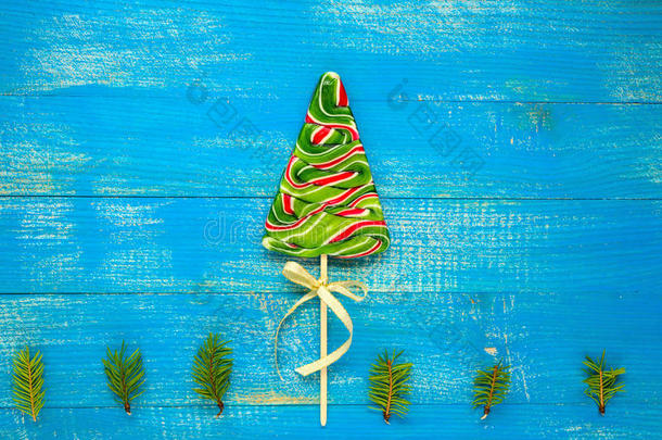 圣诞大餐：蓝色木板上云杉形式的彩色棒棒糖。